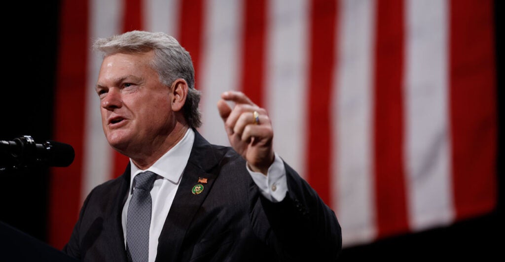 With a U.S. flag as backdrop, Rep. Mike Collins, R-Ga., speaks at the Cobb Energy Performing Arts Centre on Oct. 15 in Atlanta, Georgia.