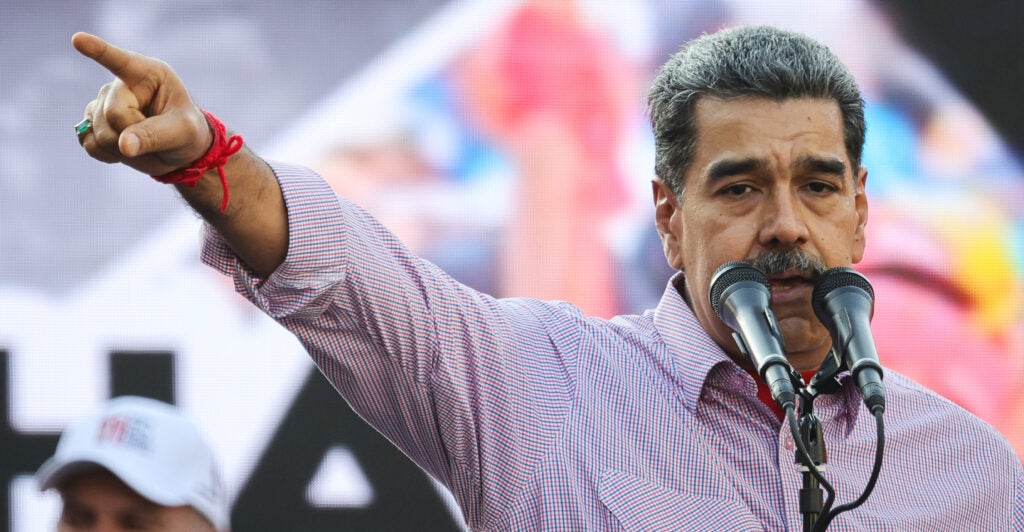 Nicolas Maduro delivering a speech, pointing to his right.