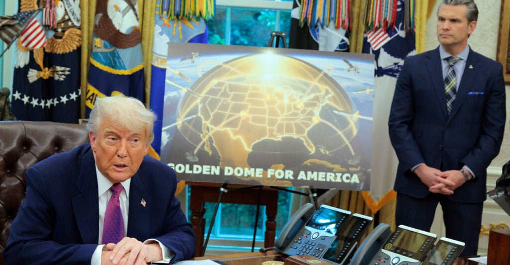 President Donald Trump and Secretary of Defense Pete Hegseth, in the Oval Office on Tuesday, unveil plans for a missile-defense shield system, with an artist's rendering of what it would look like between them.