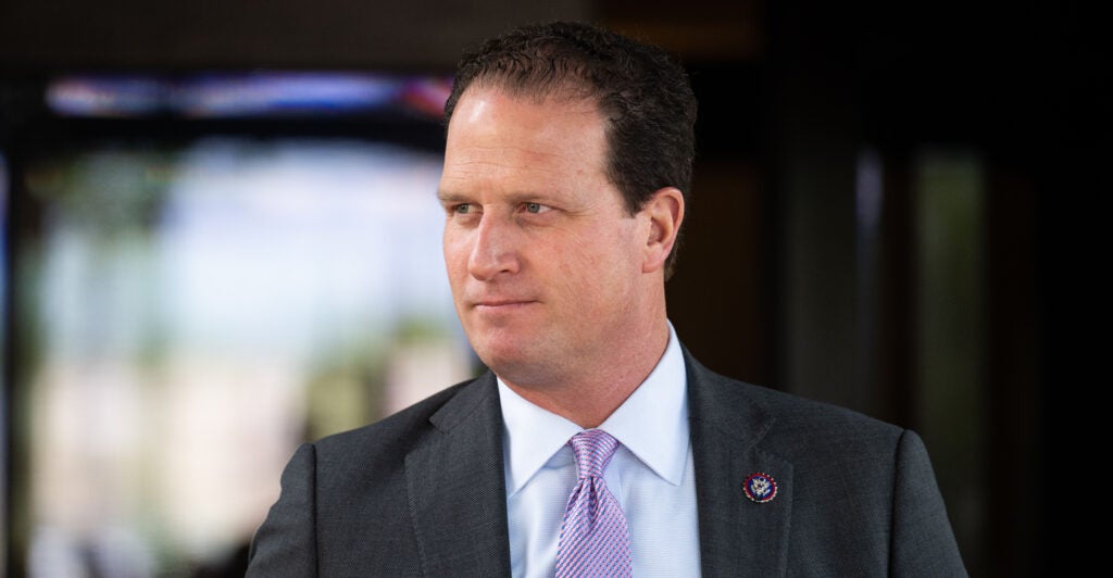 Rep. August Pfluger in dark jacket and lavender tie, looking to his right.