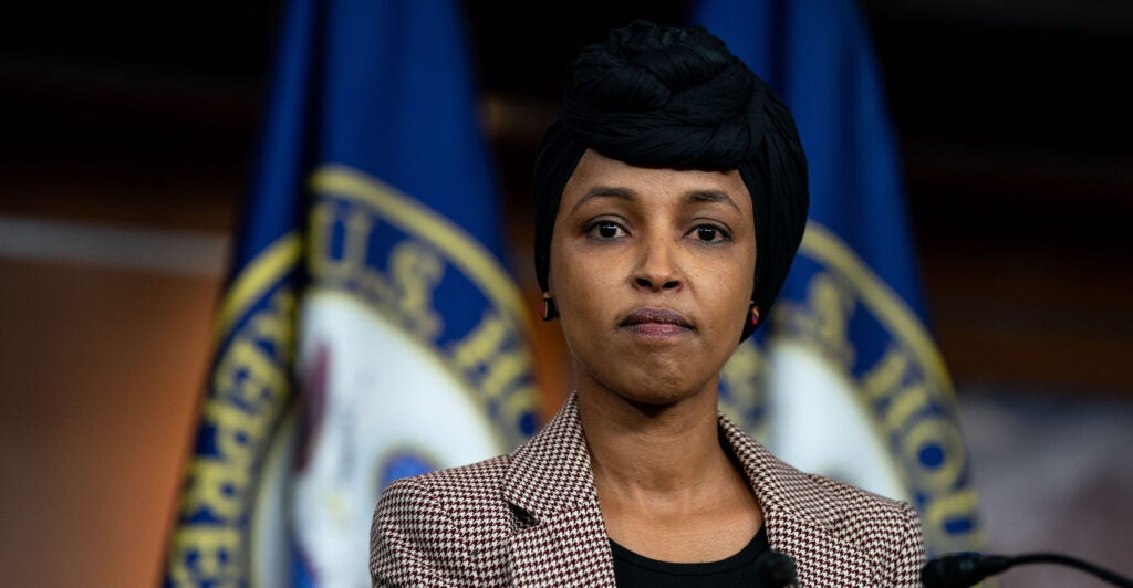 Ilhan Omar wear stands wearing a black hajib.