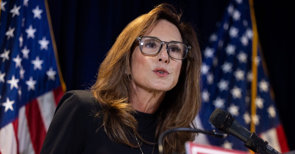 House Republican Conference Chairwoman Lisa McClain, R-Mich., with two U.S. flags as backdrop