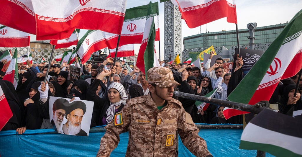 Iranians wave the country's flags during a ceremony commemorating the anniversary of the death of Iranian President Ebrahim Raisi on May 15 in Tehran, Iran.