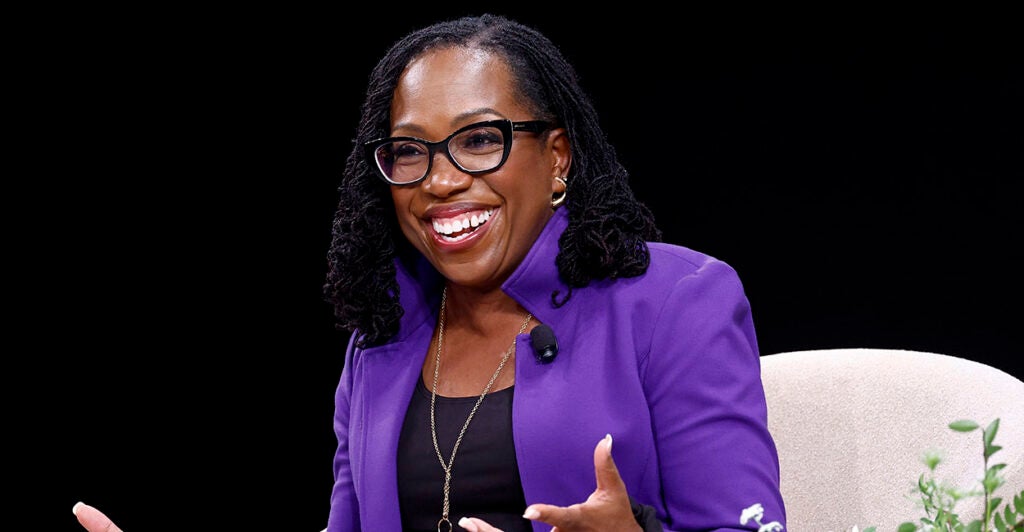 A smiling Ketanji Brown Jackson wearing a purple jacket.
