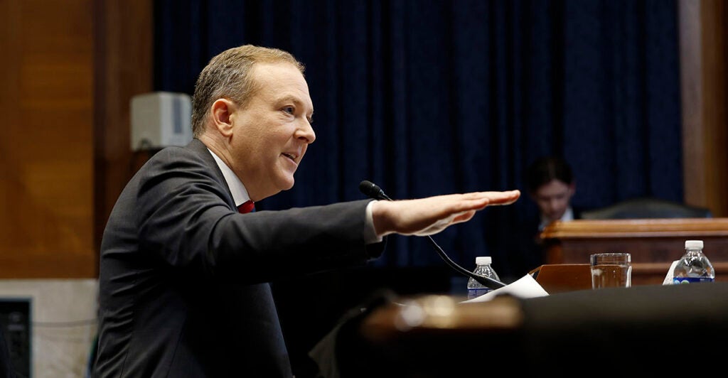 Lee Zeldin in a suit gestures with his hand