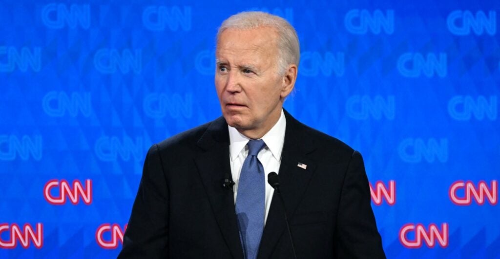 Joe Biden stands with a confused look on his face and he looks to his left during a debate.