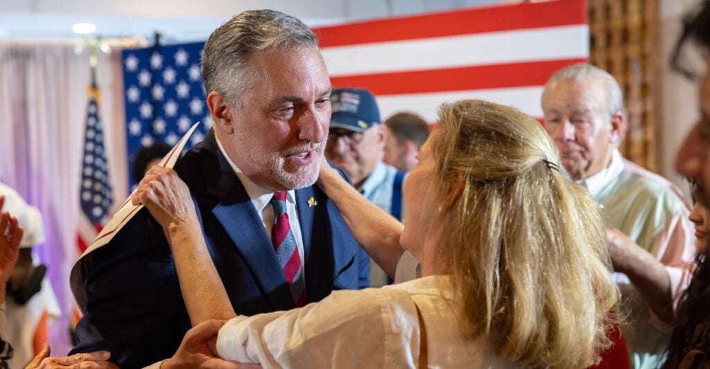 Republican candidate for Virginia lieutenant governor, John Reid, hugs a female supporter at a rally
