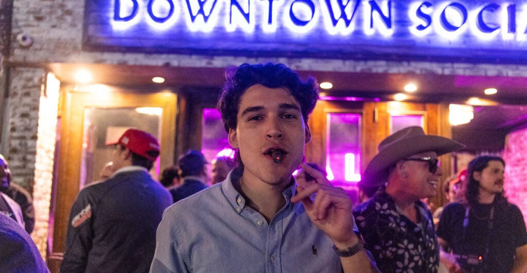 A young Donald Trump supporter smokes a victory cigar at a victory party Election Night 2024.