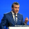 Defense Secretary Pete Hegseth in a blue suit against a blue background makes a point at the Shangri La Dialogue Summit in Singapore.