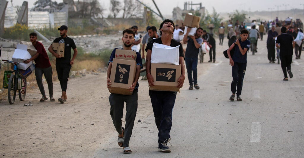 People carry relief supplies from the Gaza Humanitarian Foundation.