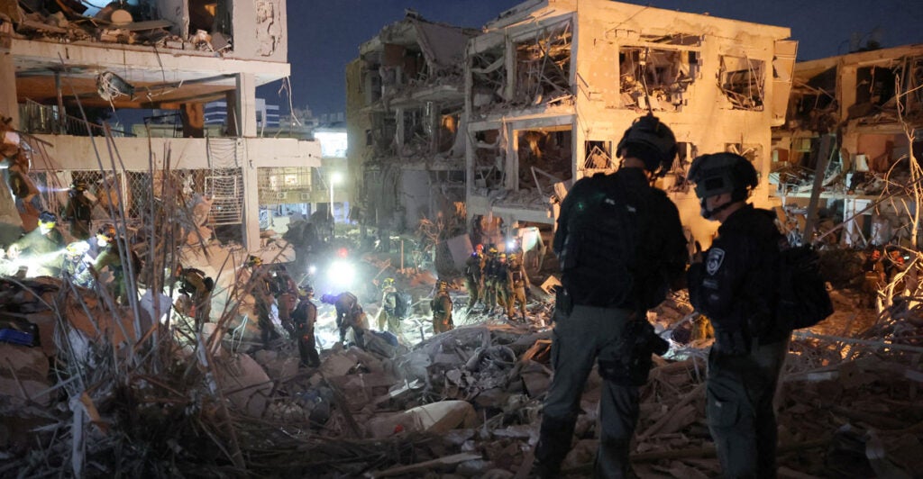 Responders search through building rubble following a strike by an Iranian missile in the Israeli city of Bat Yam near Tel Aviv.