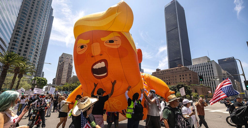 The "Baby Trump" balloon being held up by a group of protesters at the "No Kings" demonstration in L.A.