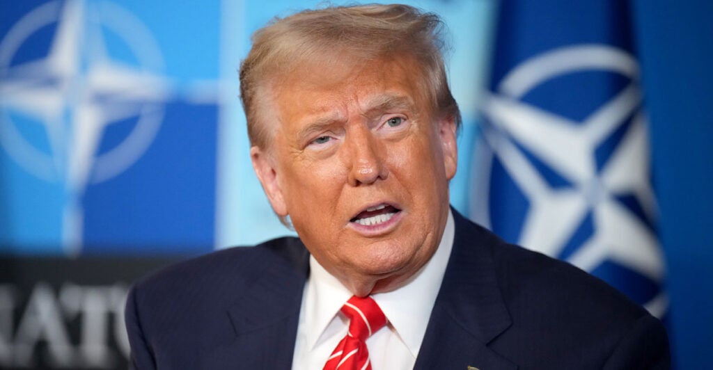 President Donald Trump with NATO flags behind him