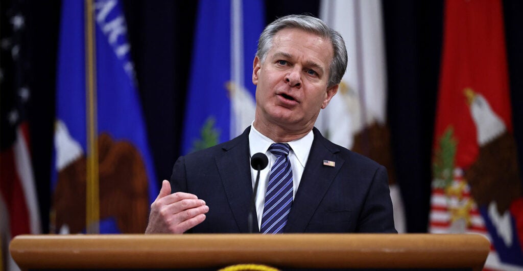 Then FBI Director Christopher Wray in a suit with an American flag pin.