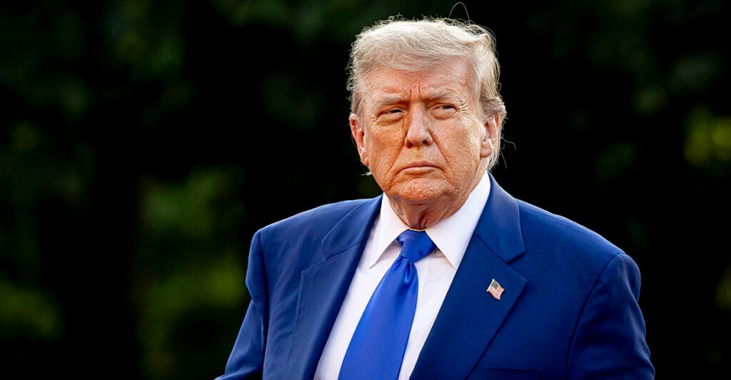 Donald Trump in a blue suit stares resolutely