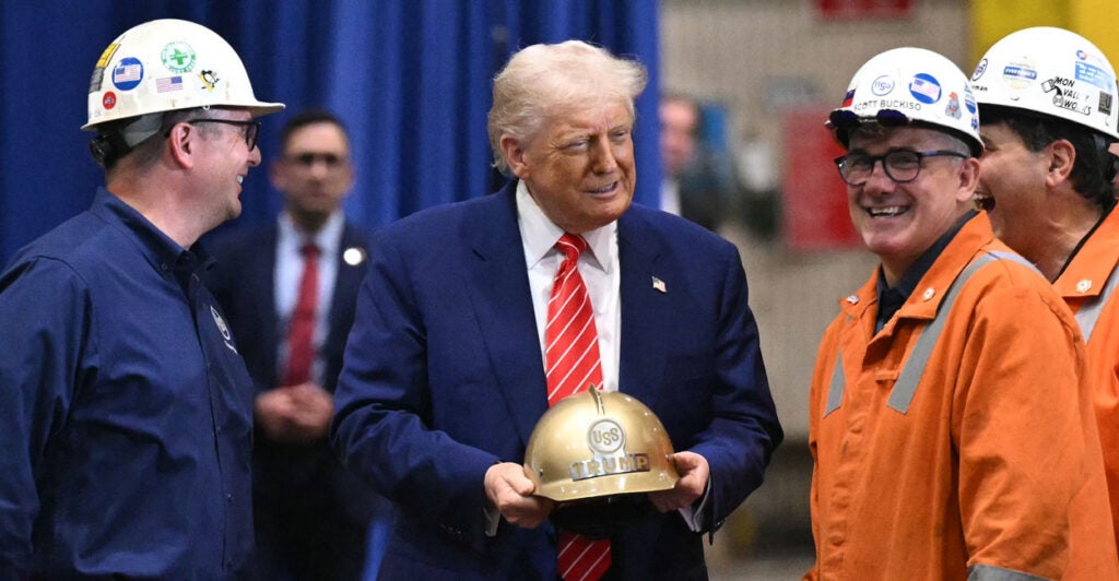 President Donald Trump chats it up with steelworkers wearing hard hats who presented him with one of his own with his name on it.