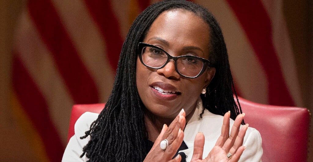 Ketanji Brown Jackson in a cream suit in front of an American flag