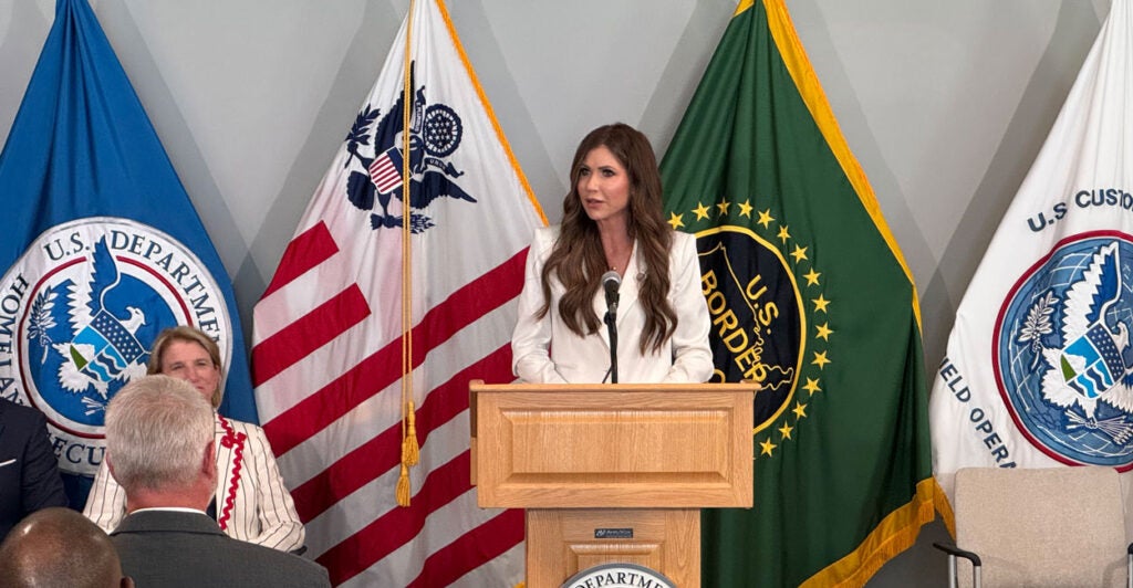 With a backdrop of several flags, DHS Secretary Kristi Noem speaks at Customs and Border Protection’s Advanced Training Center in Harpers Ferry, West Virginia, on Monday.