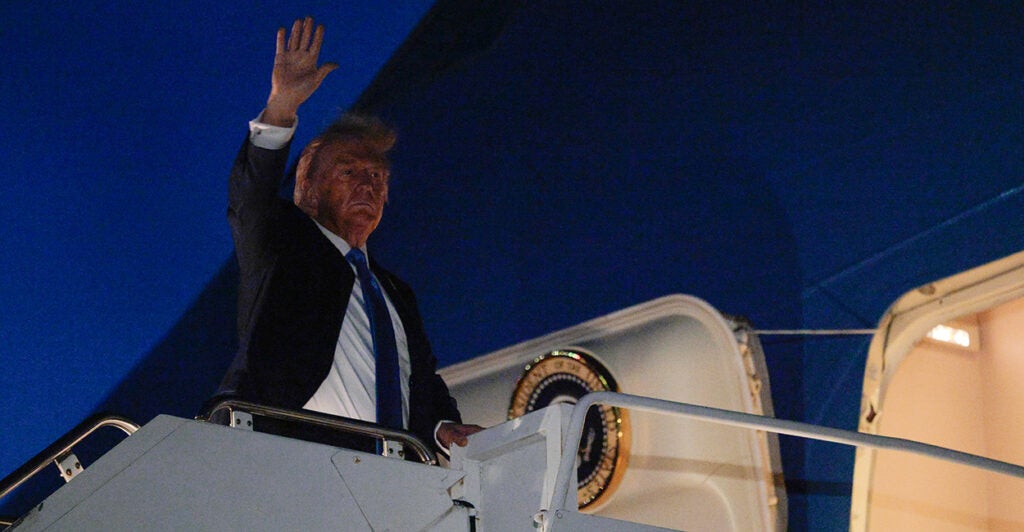 President Trump waves from the top of the stairs entering Air Force One before departing Canada late Monday night.