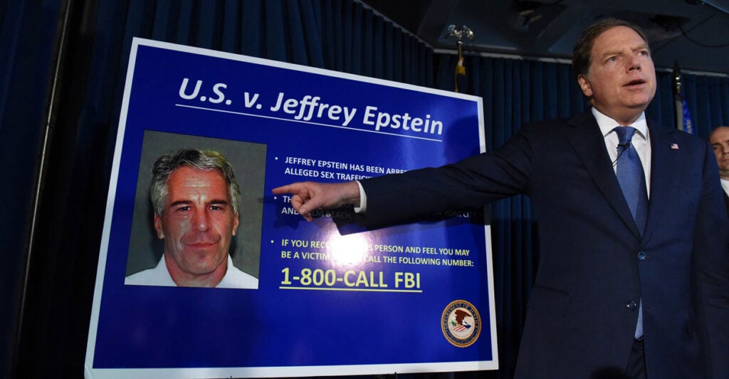 U.S. Attorney for the Southern District of New York Geoffrey Berman points to a photo of Jeffrey Epstein with his right hand.