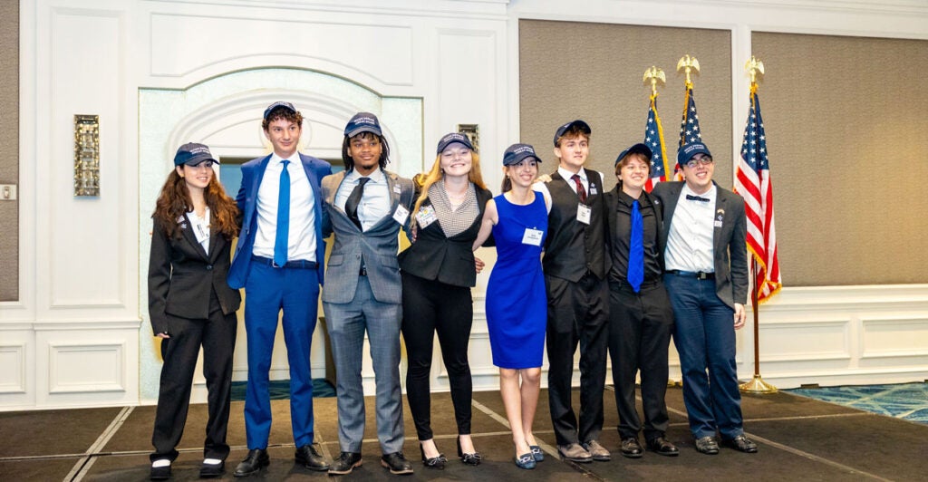 A line of young, nicely dressed teenage boys and girls, arm-in-arm at the Incubate Debate national championships.
