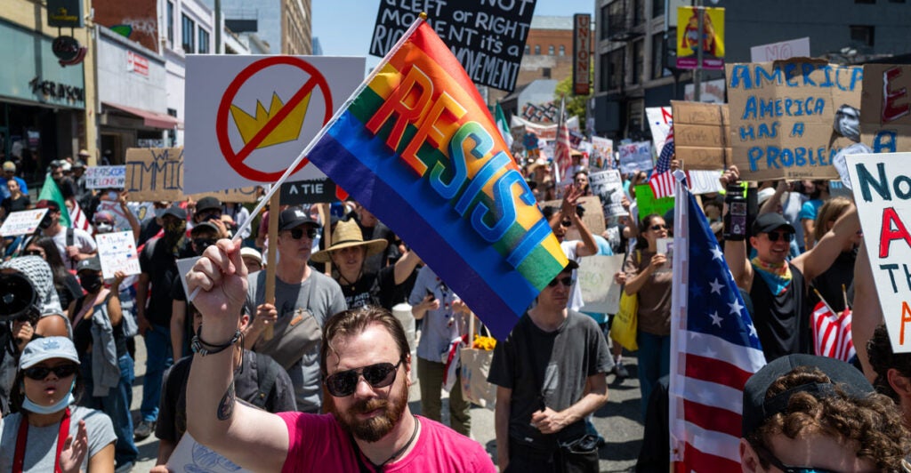 Protesters with signs and flags fill a street in Los Angeles during a "No Kings" demonstration.