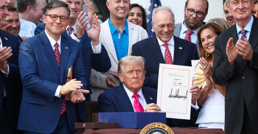 With congressional backers looking on, President Donald Trump signs the One, Big Beautiful Bill into law on July 4.