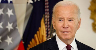 Close-up of Joe Biden standing in front of American flag.