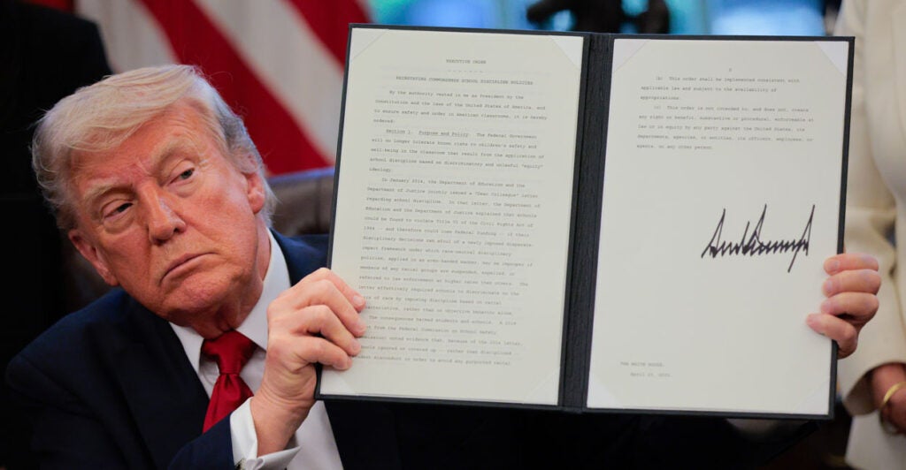 Donald Trump displays a signed executive order.