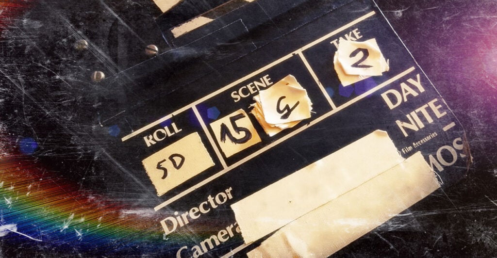 A movie clapperboard against a spacy black and rainbow background.