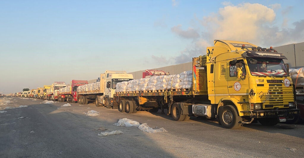 Yellow trucks carrying humanitarian aid line up to enter Gaza.