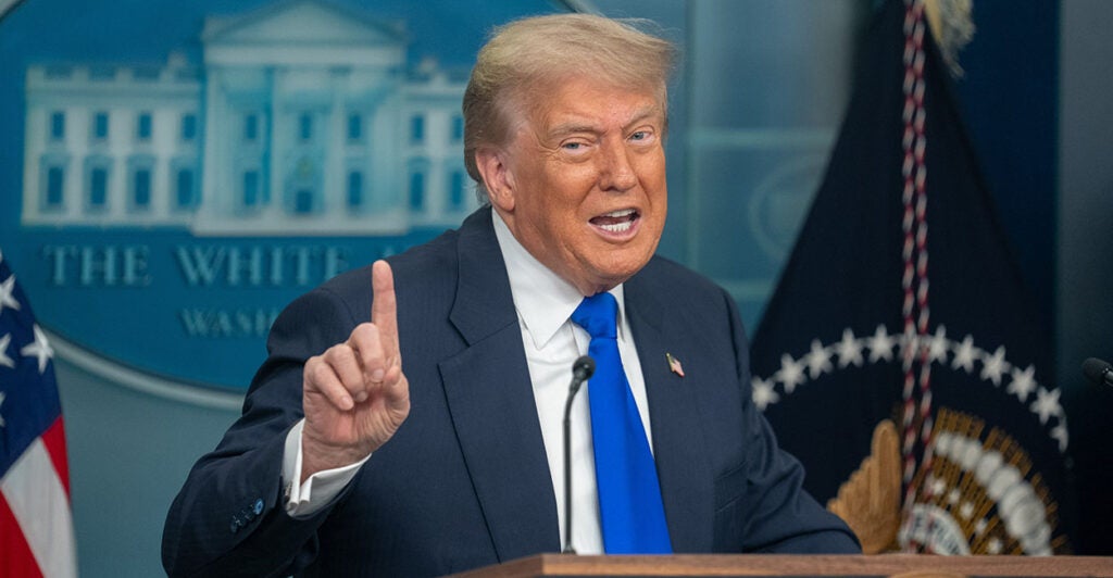 Donald Trump in a blue suit wags his finger