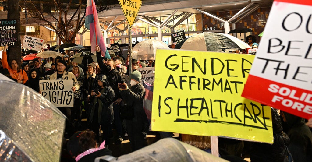 Activists with gender-affirming care signs.