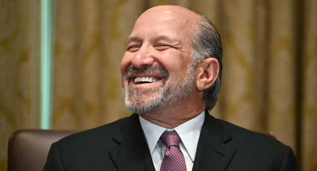 Lutnick smiles with closed eyes at the camera.