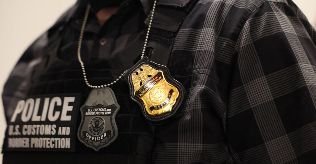Close up of ICE agent vest and badge.