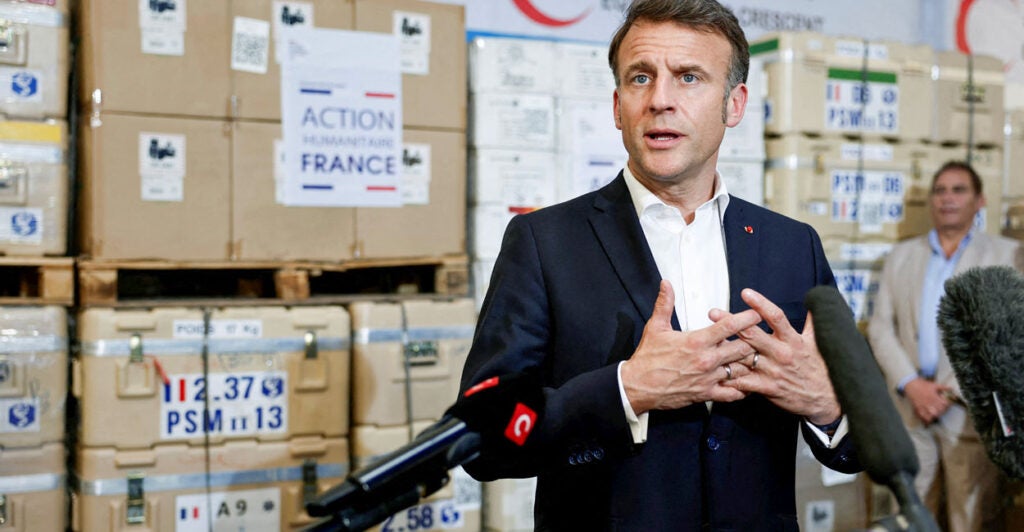French President Emmanuel Macron talks to reporters during a visit at Egyptian Red Crescent warehouses storing aid for Gaza in the Egyptian border town of El-Arish, Egypt, on April 8.