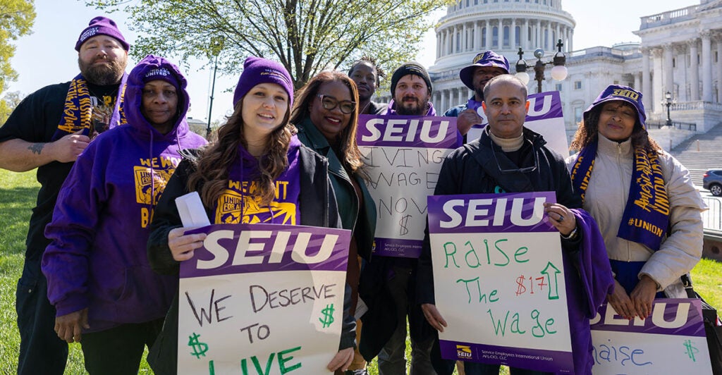 SEIU President April Verrett and others pose in front of the Capitol