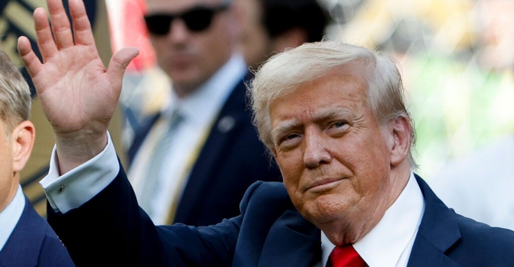 President Donald Trump waves to onlookers.