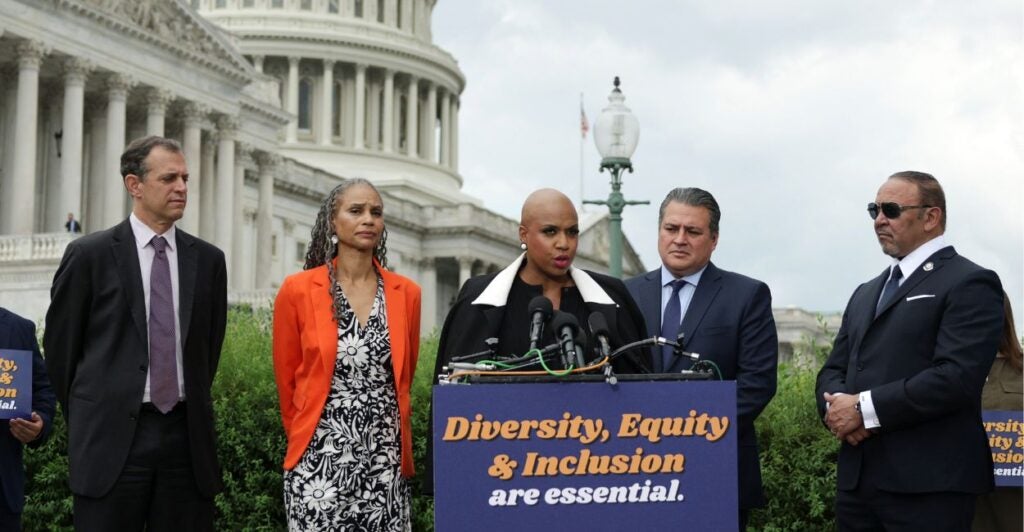 Rep. Ayanna Pressley speaks into the microphone at her press conference, with her supporters on either side.