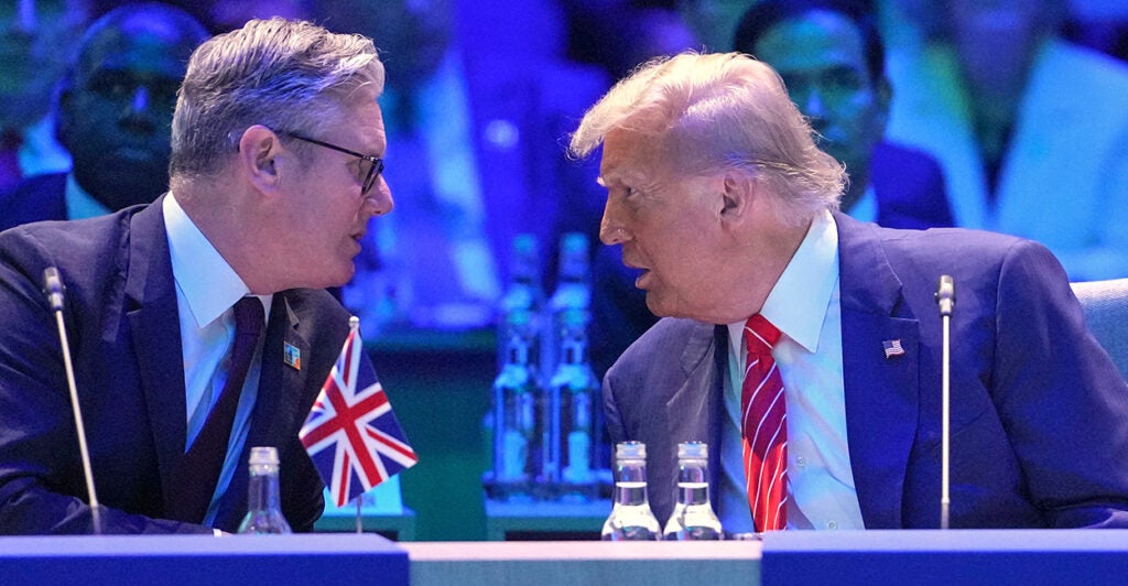 President Donald Trump and UK Prime Minister lean in to talk at the 2025 NATO Summit.