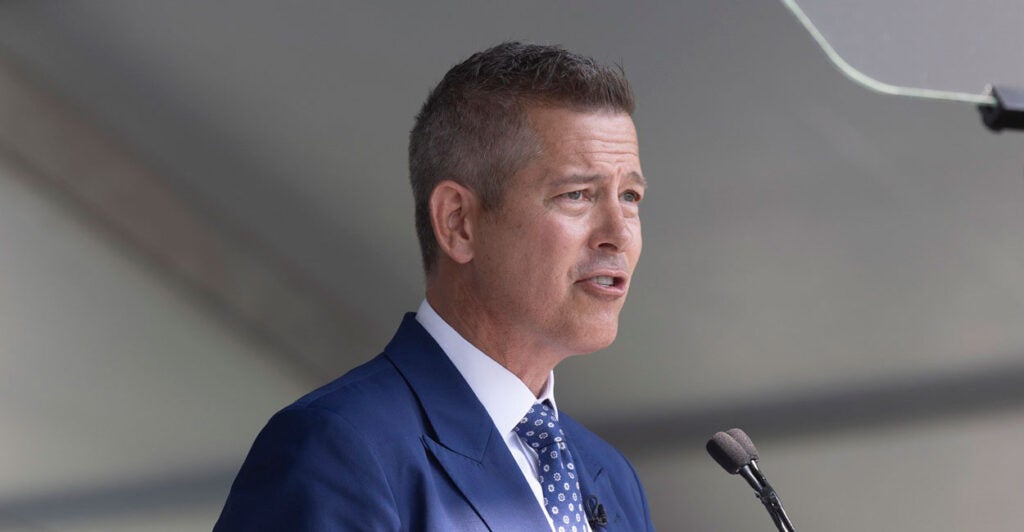 Sean Duffy looks straight ahead as he stands behind a podium and speaks into a microphone.