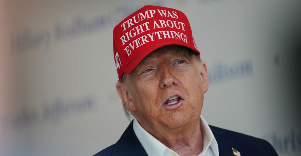 Donald Trump speaks to the media wearing a hat that reads, "Trump Was Right About Everything!"