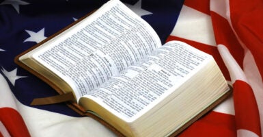 An opened Bible rests atop a U.S. flag