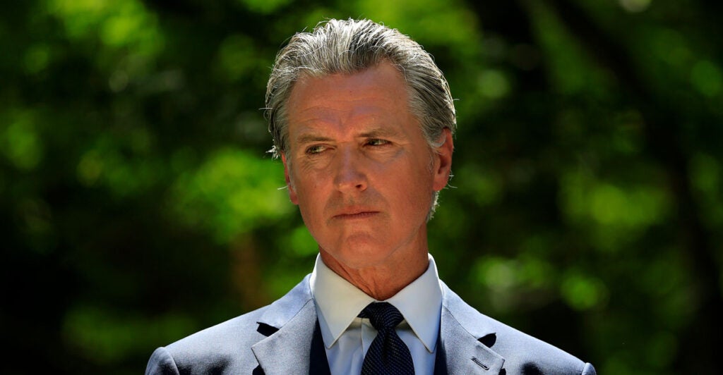 California Gov. Gavin Newsom stares off to the side and glares.