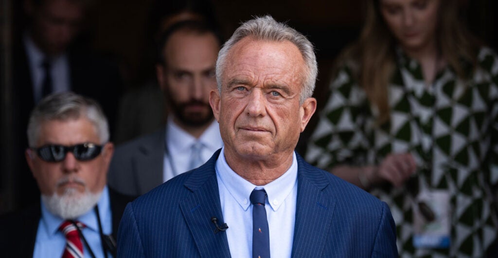 Robert F. Kennedy Jr. in a blue suit and tie, looks into the camera.