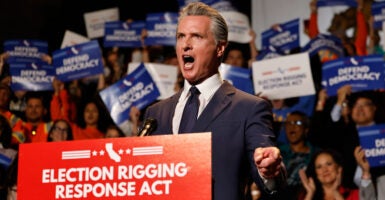 Gavin Newsom yells while standing behind podium reading "Election Rigging Response Act."