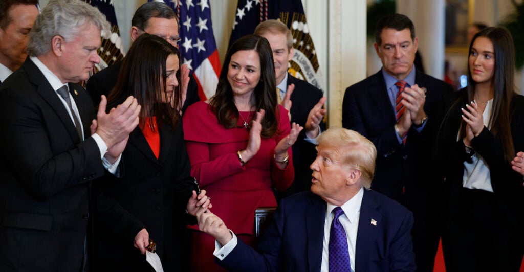 President Donald Trump hands a pen to Laken Riley's mother, Allyson, after using it to sign the Laken Riley Act into law on Jan. 29. (Chip Somodevilla/Getty Images)