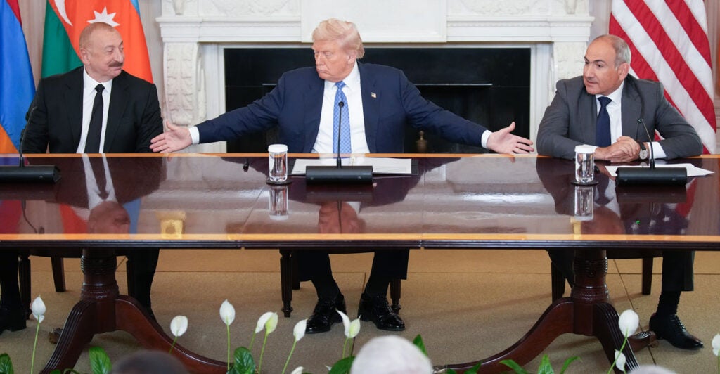 President Trump spreads his arms out toward Azerbaijani President Ilham Aliyev (L) and Armenian Prime Minister Nikol Pashinyan (R) during a signing ceremony at the White House.