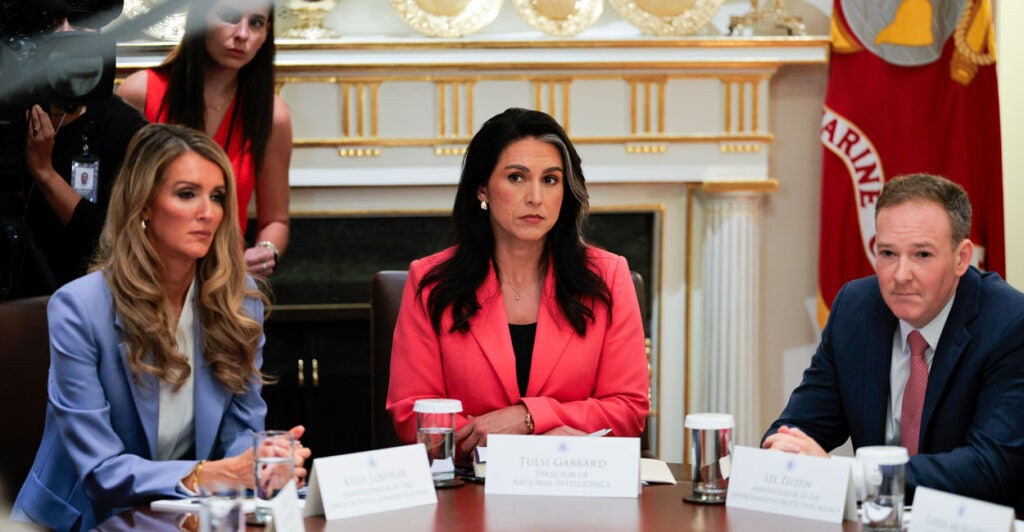 Tulsi Gabbard, flanked on her left by Lee Zeldin, and on her right by Kelly Loeffler, listens in during a White House Cabinet meeting.