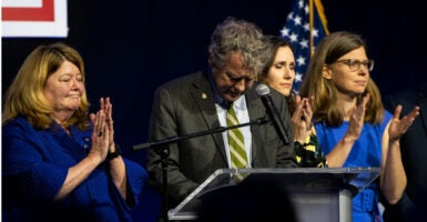 Former Sen. Sherrod Brown looks down solemnly while standing at a podium.